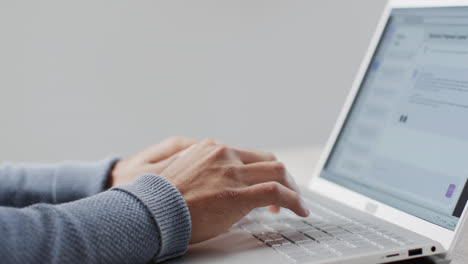 Video-of-biracial-businessman-using-laptop-on-white-background