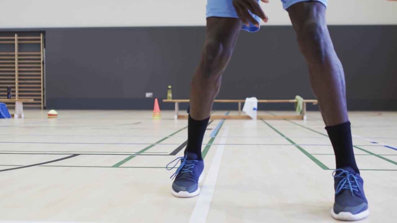 retrato de un jugador de baloncesto afroamericano jugando en una cancha cubierta, en cámara lenta