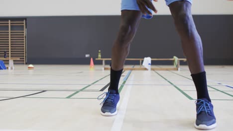 Porträt-Eines-Afroamerikanischen-Männlichen-Basketballspielers,-Der-In-Zeitlupe-Auf-Dem-Hallenplatz-Spielt