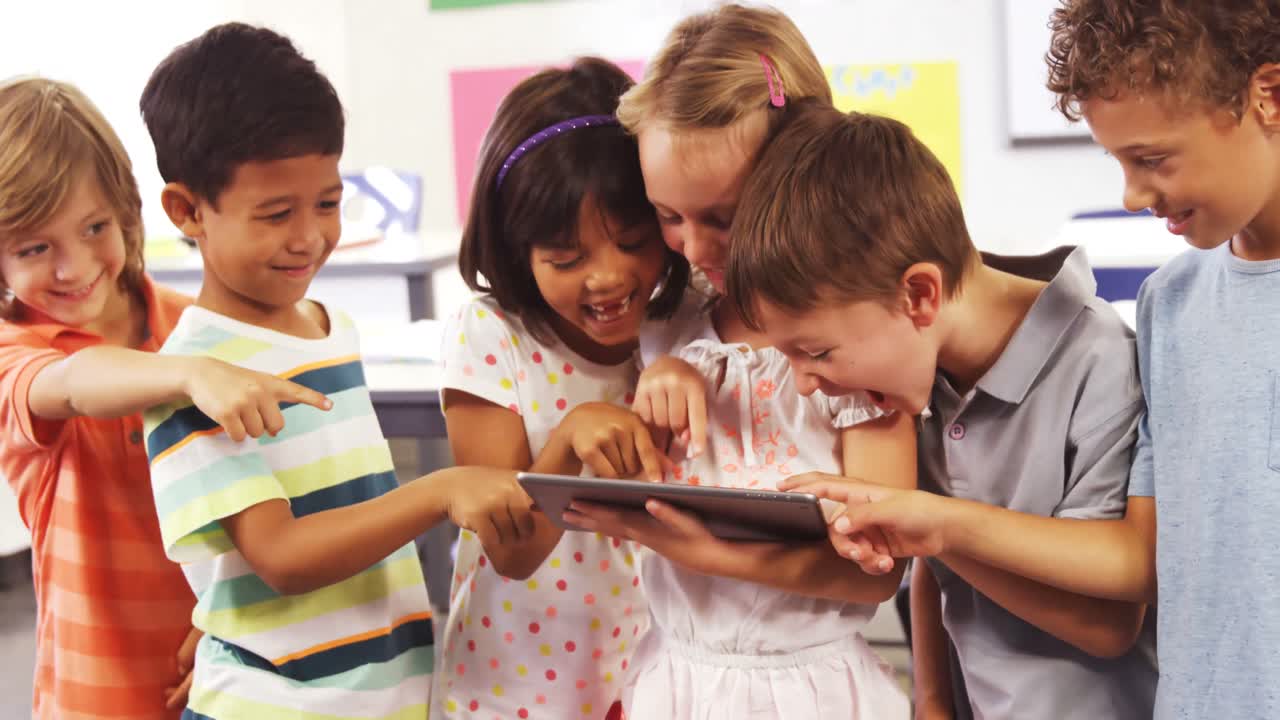 niños usando y riendo juntos frente a la computadora tableta