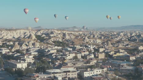 goreme village cappadocia hot air balloons in sky establishing shot