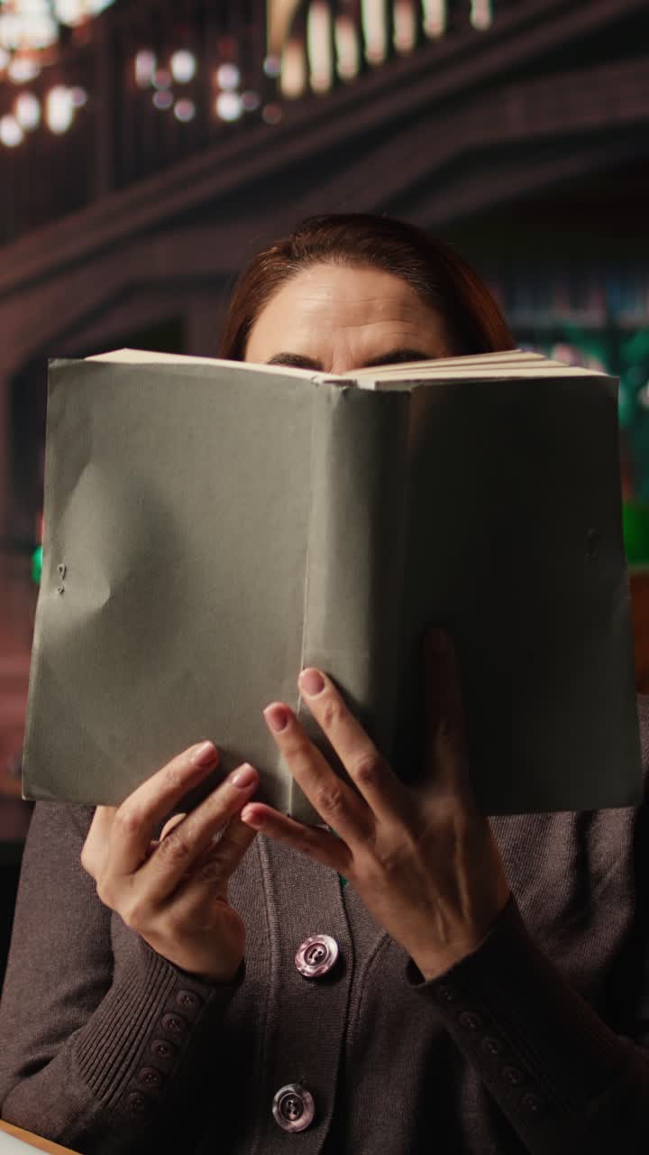 Vertical Video Older woman paying attention to reading hobby at the public library