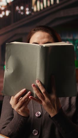 vertical video older woman paying attention to reading hobby at the public library