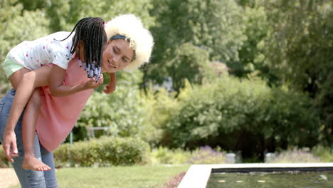 Mujer-Birracial-Dando-A-Cuestas-A-Una-Chica-Afroamericana-En-El-Parque