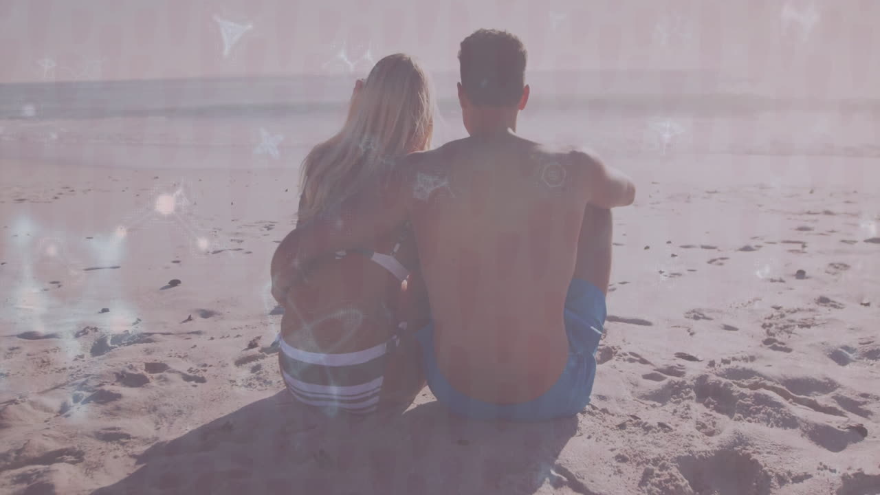couple wearing swimwear sitting on beach, with animated travel icons floating above water
