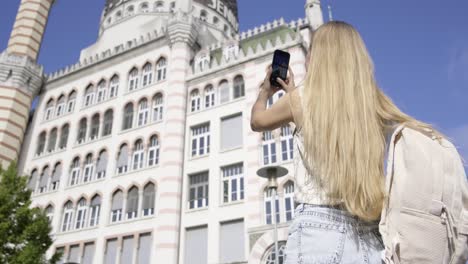 a woman gazes at a towering building against the city skyline