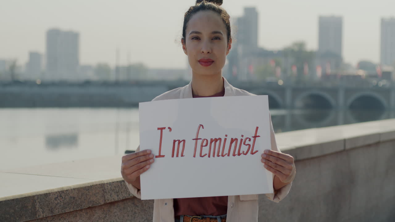 Woman holding a feminist sign in the city