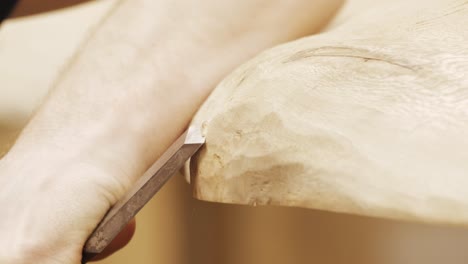 Close-shot-of-a-chisel-on-a-wooden-table