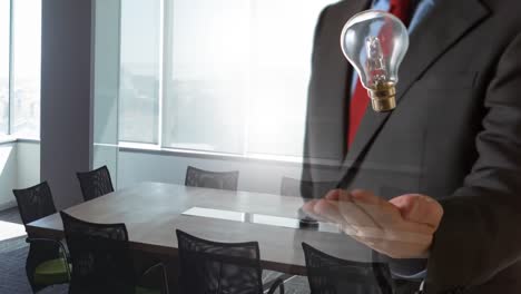 Animation-of-light-bulb-over-businessman's-hand-in-office-background
