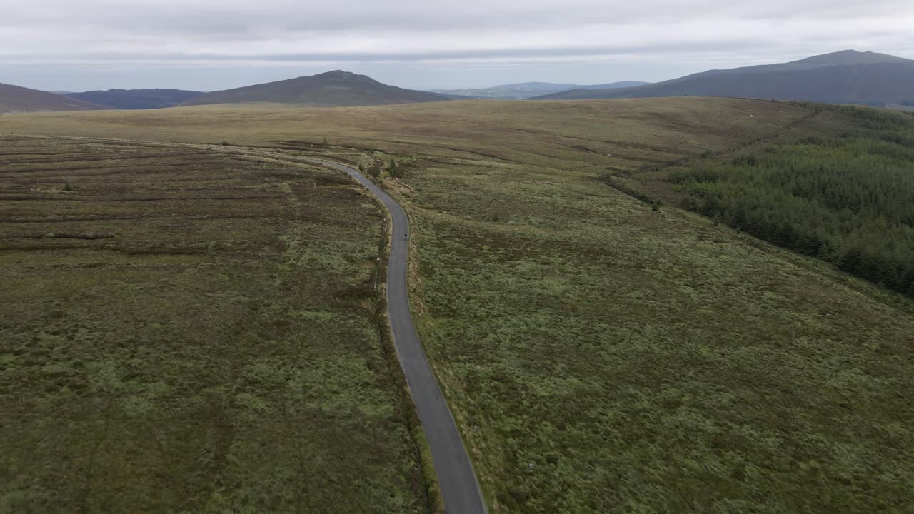 toma de un dron de una carretera de montaña con un ciclista en ella
