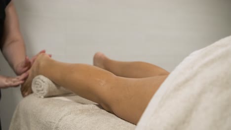 masseuse delivering a relaxing leg massage in a tranquil spa setting