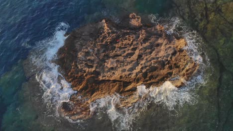 Olas-Golpeando-Rocas-Contra-Una-Pequeña-Isla-En-El-Océano