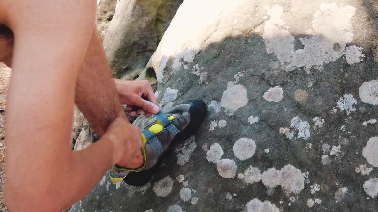joven poniéndose zapatos de escalada al aire libre rocas en el bosque de pinos de fontainebleau