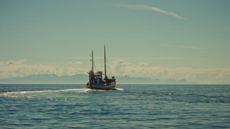 close up shot of a small fishing boat navigating on the norwegian sea, close to the lofoten islands, norway