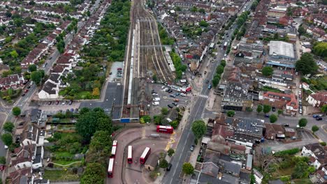 aerial static drone timelapse over chingford showing buses, traffic, pedestrians, and a train arriving and departing at the station, capturing the busy flow of urban life in london