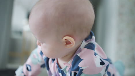 primer plano de una linda niña con un mono florido arrastrándose y jugando en el suelo