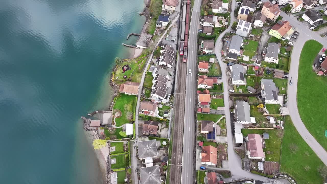 드론 촬영 새의 눈으로 볼 때 unterterzen mols walensee churfirsten 위에서 - 열차와 자동차가 도시를 통과합니다.