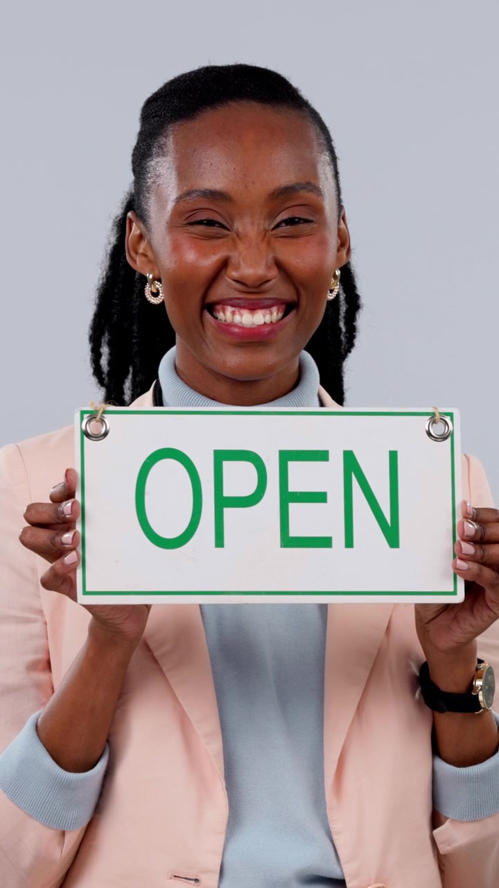 Smiling Businesswoman Holding an Open Sign