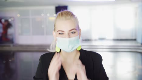 woman adjusting face mask in a building