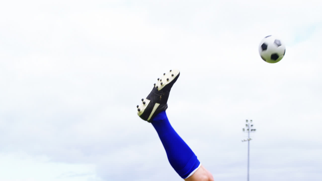 축구 선수 가 필드 에서 공 을 치고 있다