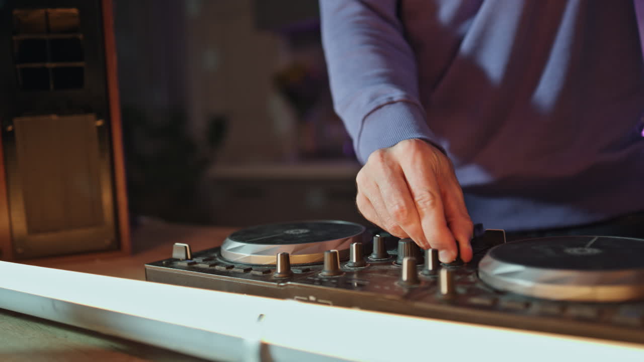 Dj hands adjusting equipment creating music mix on night party close up.