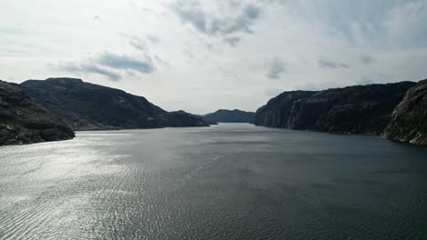 Toma-Aérea,-Descendiendo-Sobre-El-Agua-De-Lysefjord,-Noruega