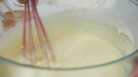 person stirring a pancake batter. close up