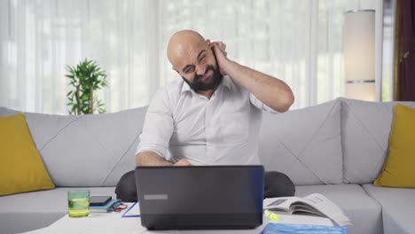 Ein-Mann,-Der-Im-Home-Office-Arbeitet,-Kratzt-Sich-An-Den-Ohren-Und-Blickt-In-Die-Kamera.