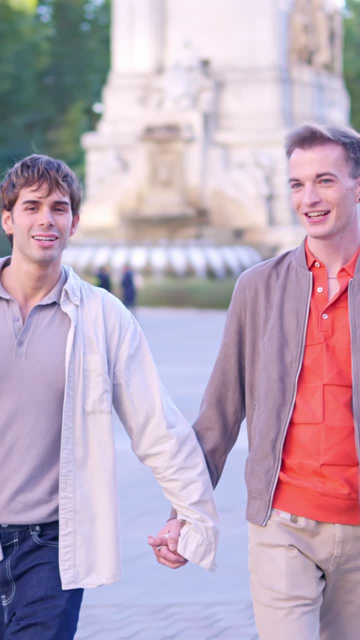 Felice coppia gay che si tiene per mano e cammina in un parco