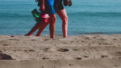 Olas-Del-Océano-En-La-Playa-Con-Una-Pareja-Pasando-Al-Fondo