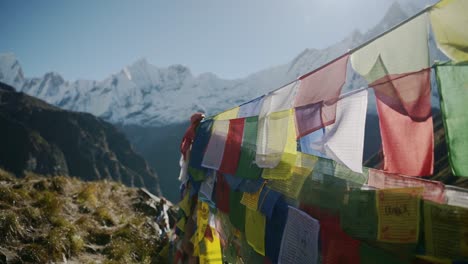 prayer flags close up in mountains in nepal, colorful tibetan prayer flags on blue sky sunny day in the snowcapped snowy himalayas in annapurna, colourful buddhism flags in nature
