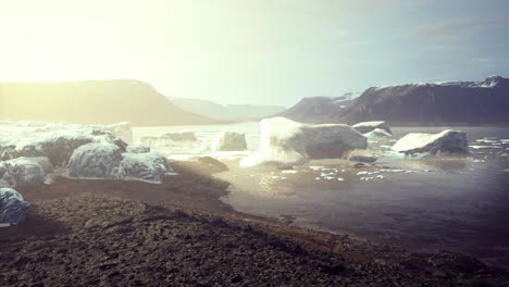 glacial landscape with floating icebergs in the sunrise over a serene lake