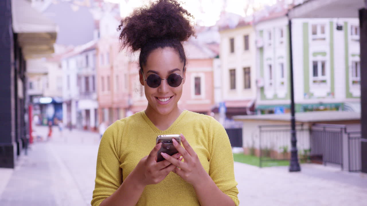 Donna elegante che usa lo smartphone in città