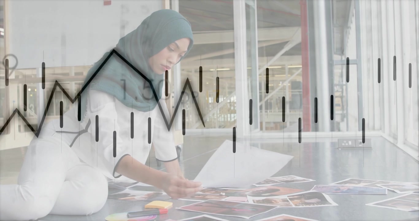 Video Vertikal: Wanita berlutut berhijab teal menyortir, mengkurasi cetakan di studio, dengan overlay yang bergeser