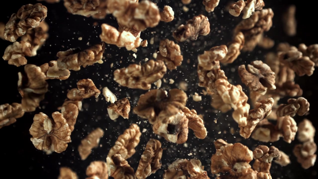 Shelled Walnuts Falling in Slow Motion Against a Black Background