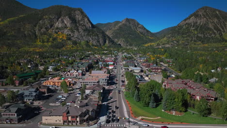 downtown frisco colorado aerial cinematic drone traffic main street early yellow fall colors aspen trees morning lake dillon keystone breckenridge silverthorne ten mile range blue sky upward motion