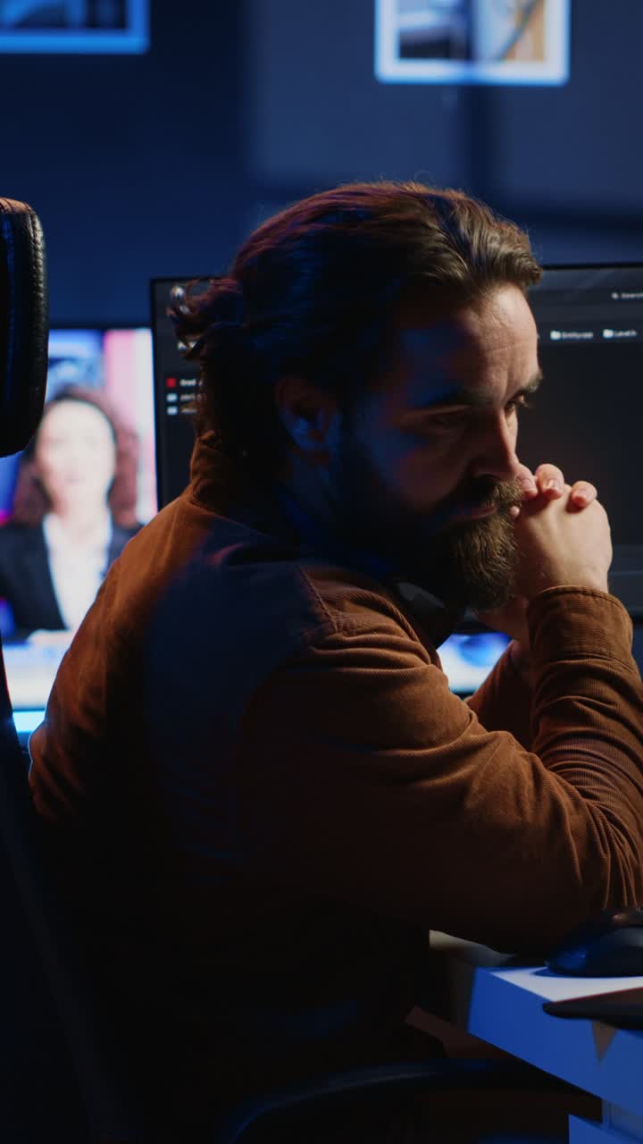 Man Working on Computer at Night, Taking Off Headphones