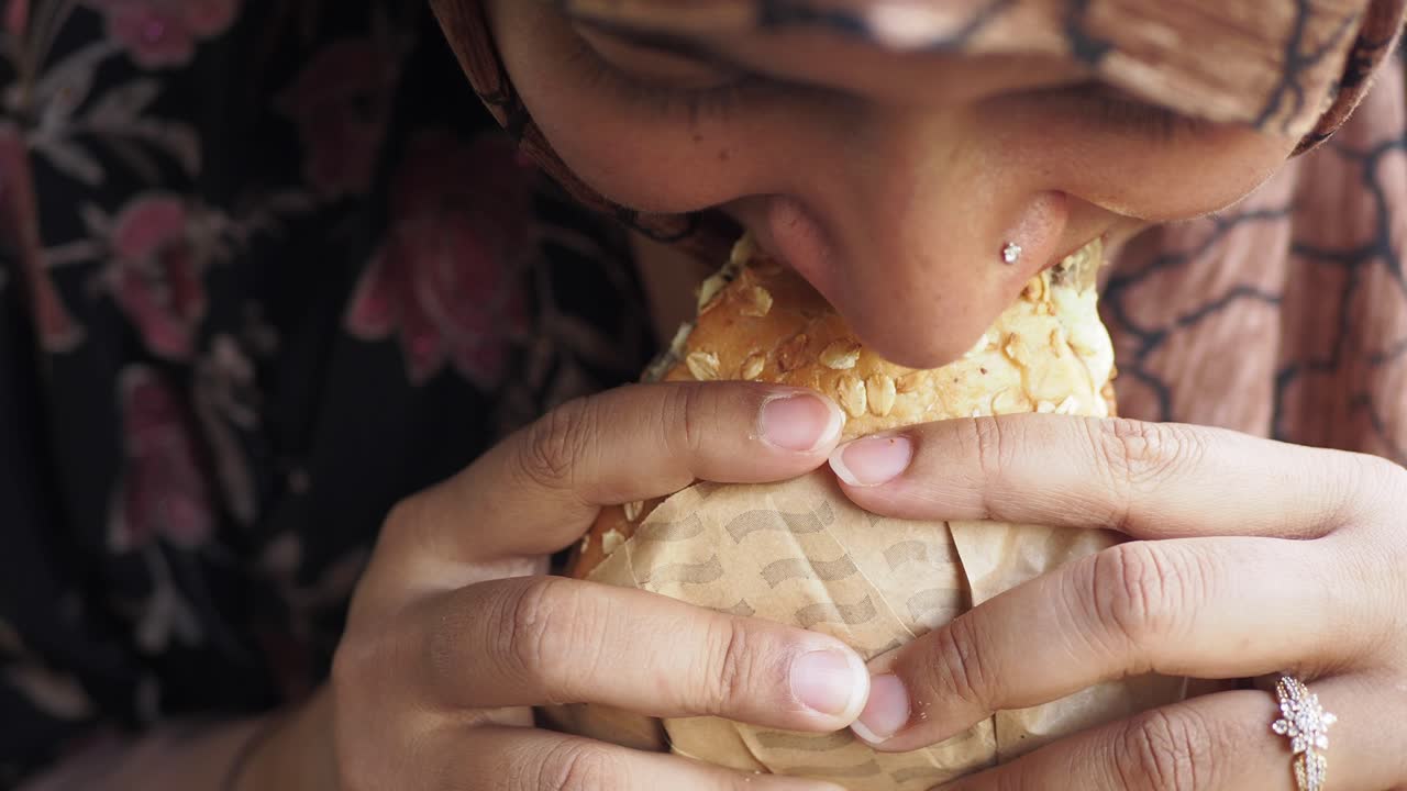 una mujer disfrutando de un delicioso sándwich.