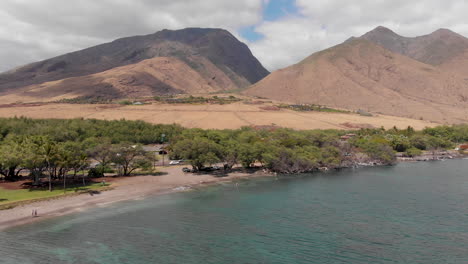 a drone shot flying toward olowalu beach park and the west maui mountains reveals a beautiful snorkeling destination