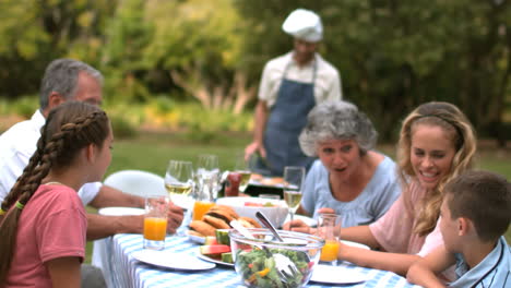 la familia comiendo en el jardín