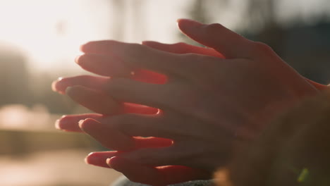 close-up shot of hands rubbing together in a gesture of deep thought or contemplation. the warm light creates a soft, introspective atmosphere, emphasizing the emotional depth and focus of the moment