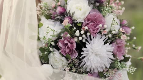 Bride-in-Her-Wedding-Gown-Holding-Pink-and-White-Flower-Bouquet-in-Her-Hands-Outdoors-with-Her-Veil-1080p-60fps