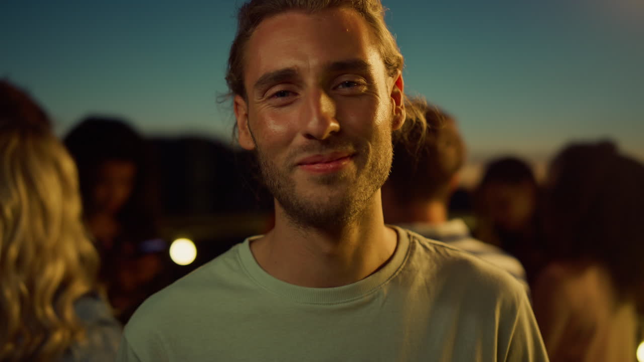 Portræt af flot fyr poserer for kameraet til dansefest. Tiltrækkende mand smiler udendørs.