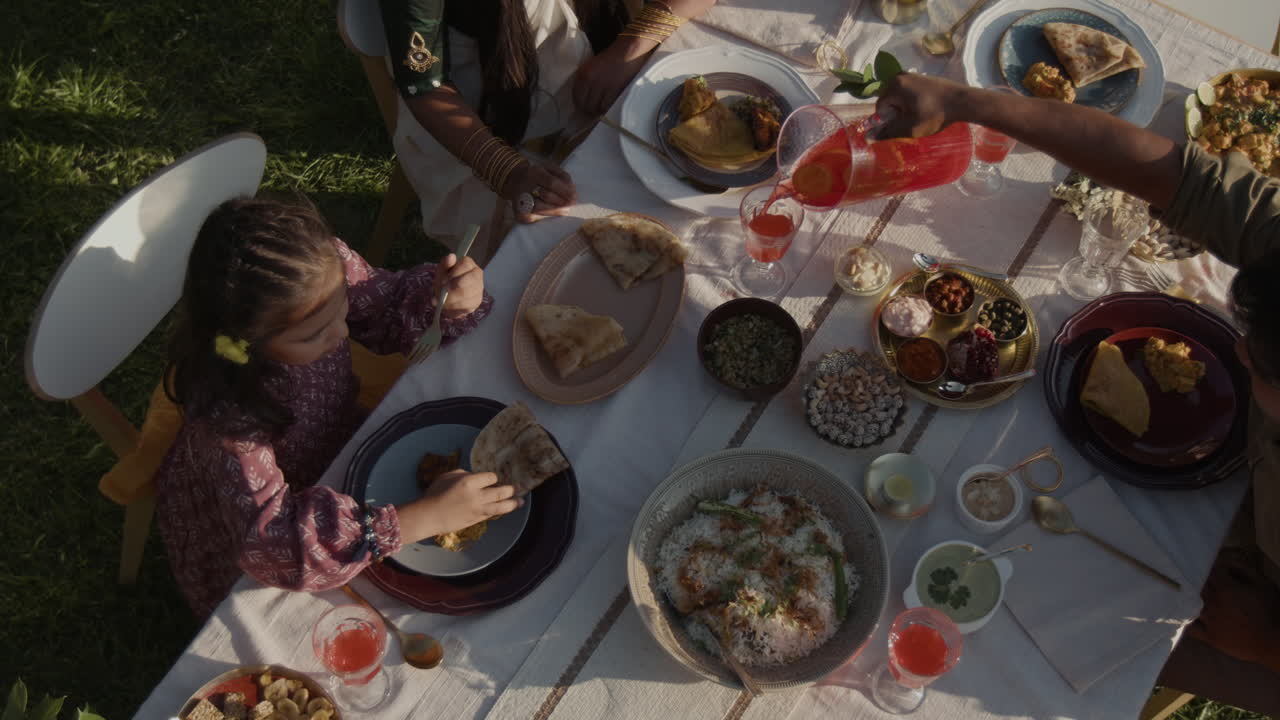 Family enjoys an outdoor feast with traditional Indian food
