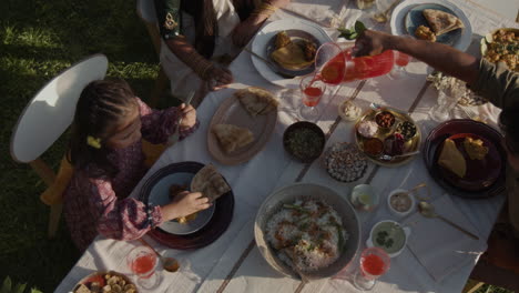 family enjoys an outdoor feast with traditional indian food