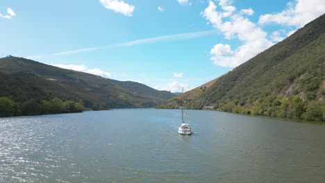 a boat crossing a river between two mountains