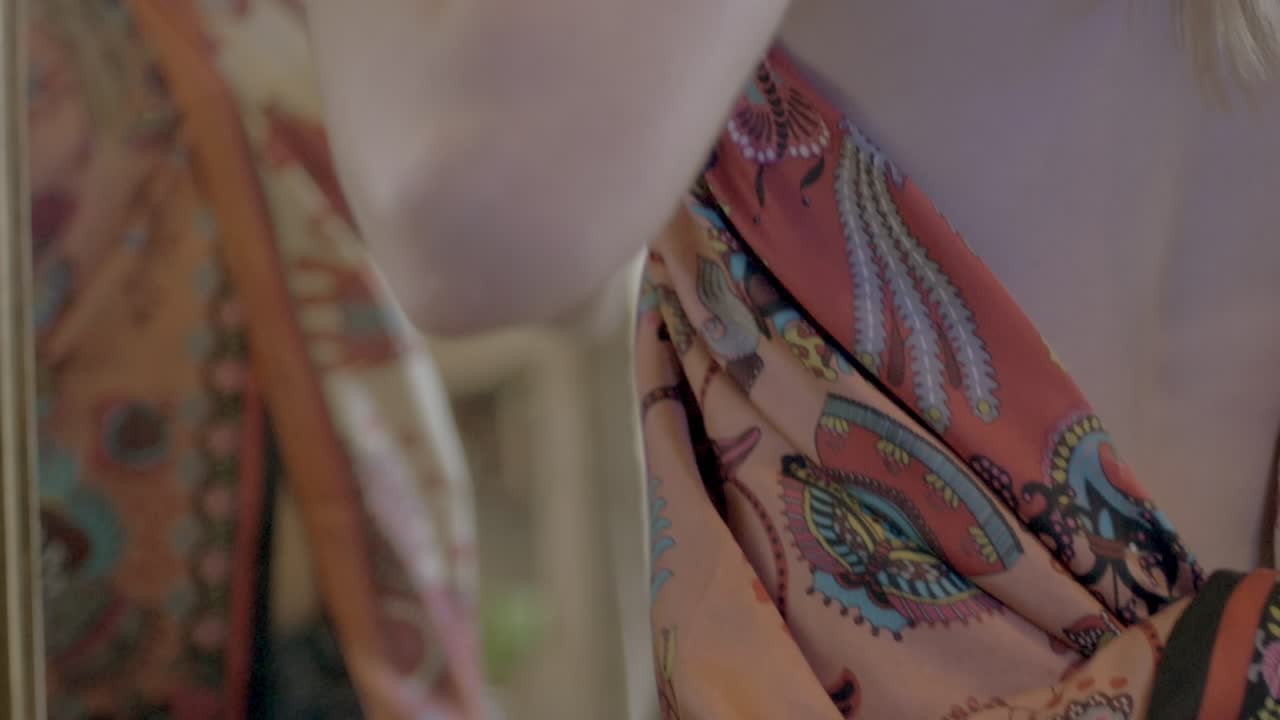 아름다운 젊은 여성의 반사, 오픈 백 블라우스를 시도