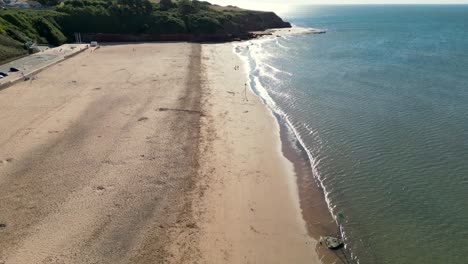 Tire-Hacia-Atrás-De-Las-Olas-Golpeando-La-Arena-De-La-Playa-Vacía-De-Exmouth,-Devon