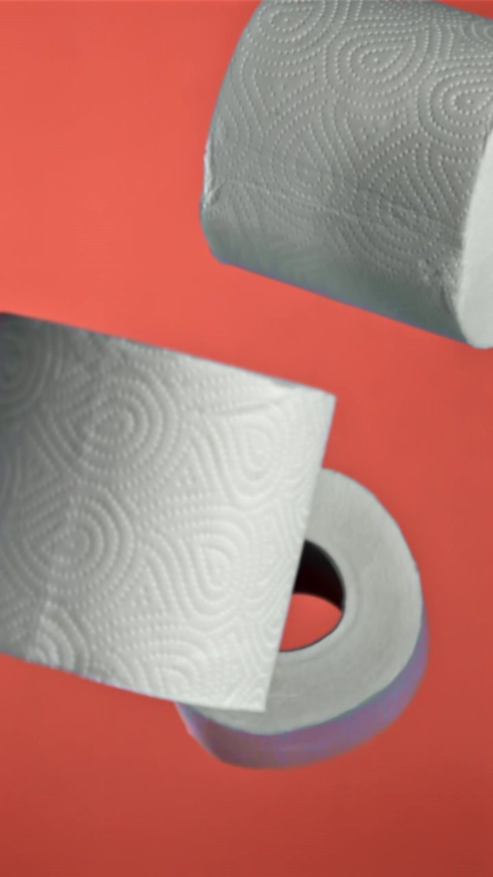 Kolme valkoista paperirullaa kohoamassa punaisella taustalla.