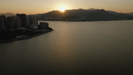 Paisaje-Urbano-Aéreo-Al-Atardecer-De-La-Metrópolis-Moderna-De-Hong-Kong-En-China-Durante-Las-Cálidas-Horas-Doradas-De-Luz